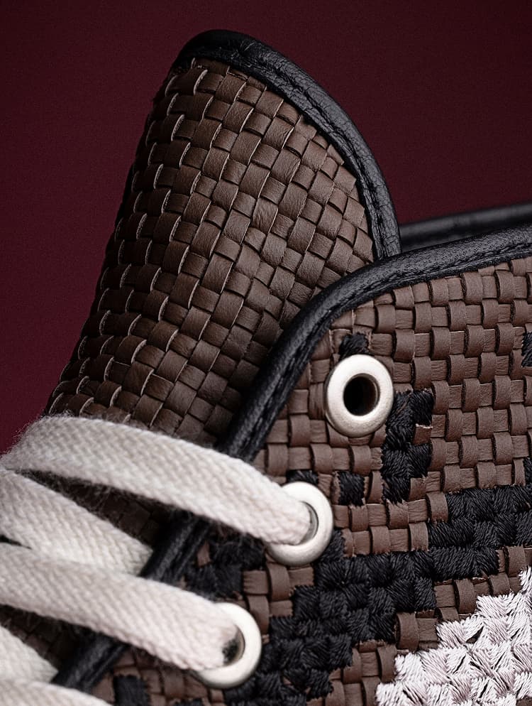 The image shows close-up views of various Converse sneakers, including a white high-top with brown stitching on the heel and a pair featuring a black-and-white floral pattern. The details highlight the textured soles, metal eyelets, laces, and embossed Converse star logos on the shoes.