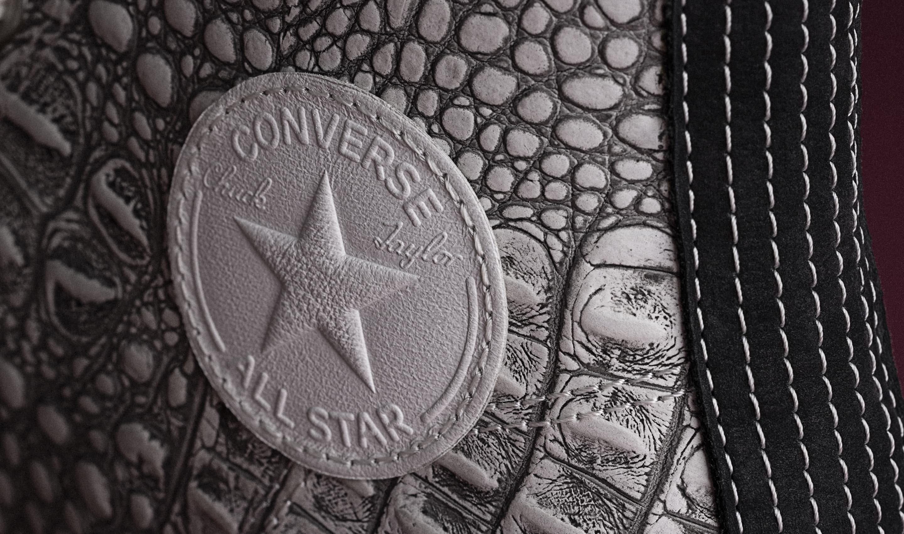 The image shows close-up views of white Converse sneakers, highlighting different styles and details like stitching, laces, and logos. The left side features a high-top with brown accents, while the right side focuses on low-top shoes with textured rubber soles.