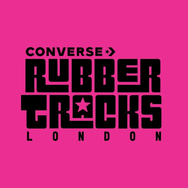 The image features bold black text on a bright pink background that reads &ldquo;CONVERSE RUBBER TRACKS LONDON,&rdquo; with a star symbol integrated into the letter &ldquo;A&rdquo; in &ldquo;TRACKS.&rdquo; It appears to be a logo or promotional graphic for Converse Rubber Tracks London.