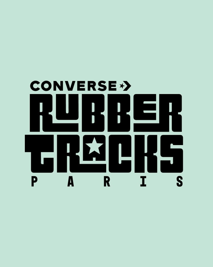 The image features a bold, stylized black text logo on a light green background that reads &ldquo;CONVERSE RUBBER TRACKS PARIS.&rdquo; The design incorporates star symbols within the words and uses a blocky, geometric font style.