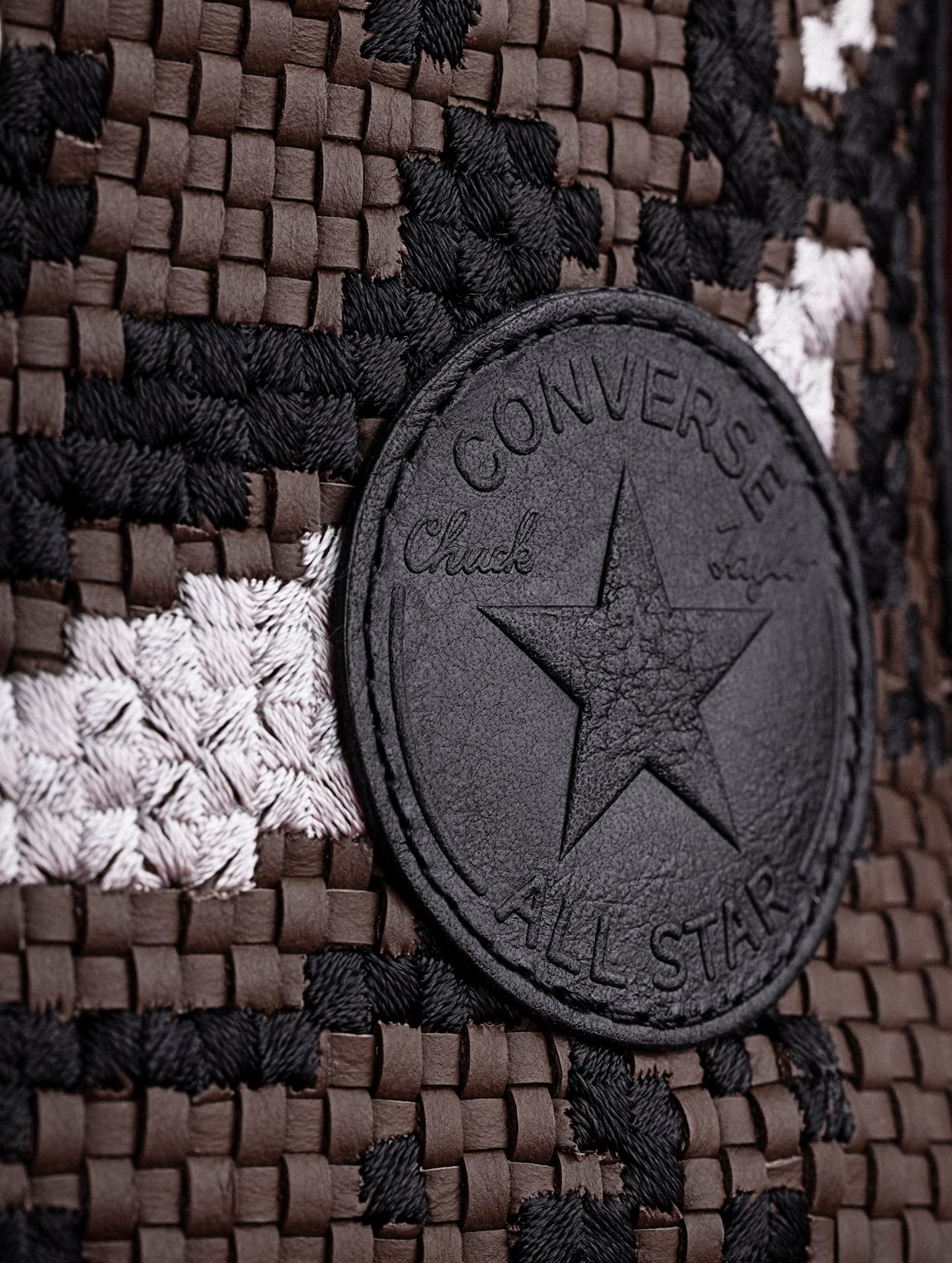 The image shows close-up views of white Converse sneakers, highlighting different styles and details like stitching, laces, and logos. The left side features a high-top with brown accents, while the right side focuses on low-top shoes with textured rubber soles.