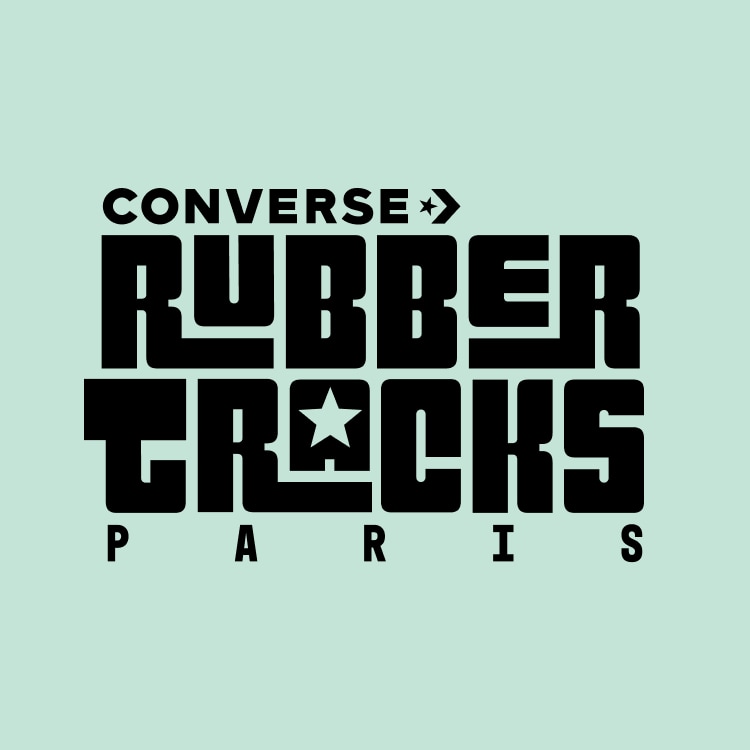 The image features a bold, black graphic text logo on a light green background that reads &ldquo;CONVERSE RUBBER TRACKS PARIS.&rdquo; The design incorporates a star symbol within the letter &ldquo;A&rdquo; in &ldquo;TRACKS,&rdquo; emphasizing the Converse brand identity.