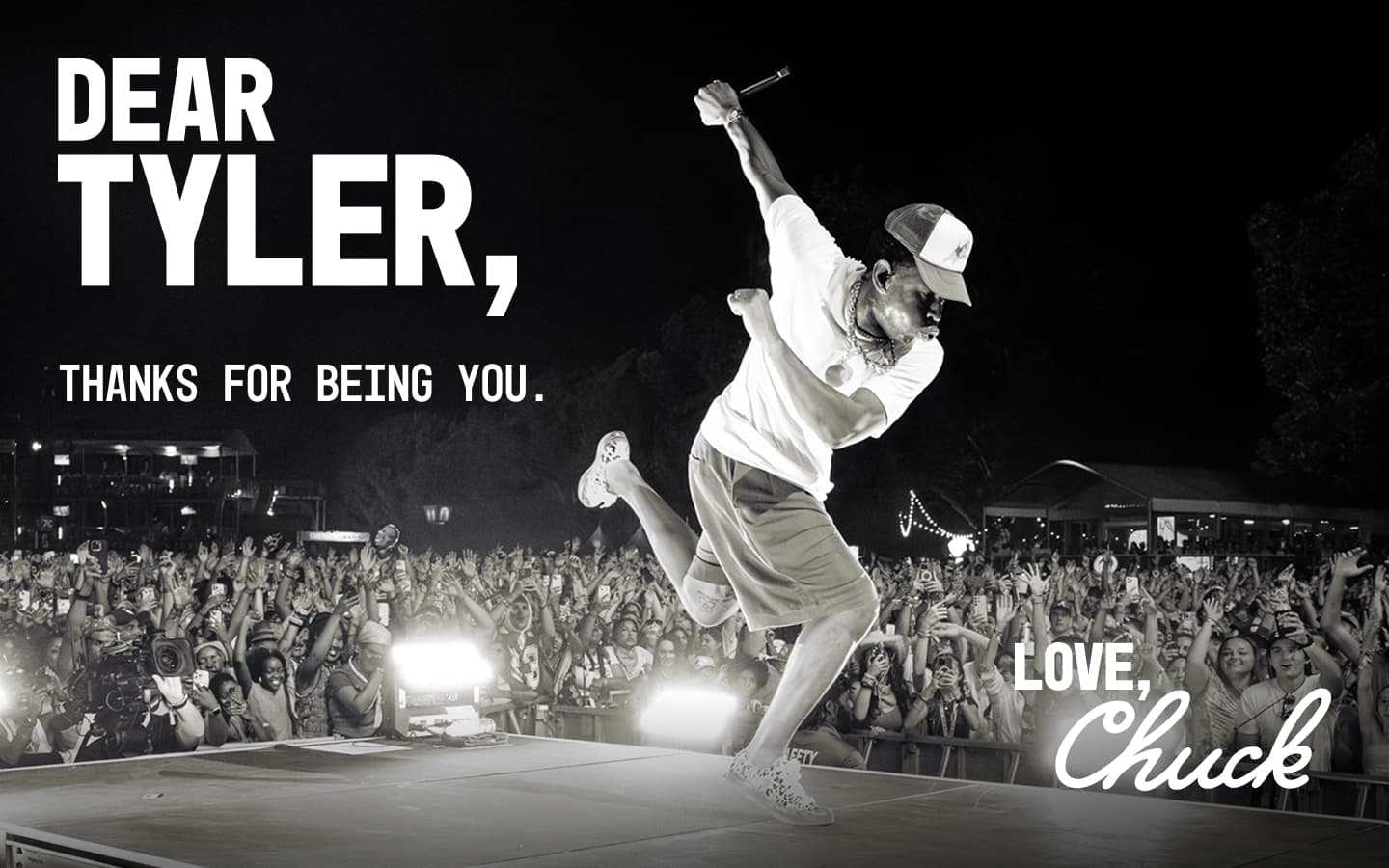 A performer energetically jumping on stage during a nighttime concert, with a large cheering crowd in the background and text expressing gratitude to Tyler from Chuck.