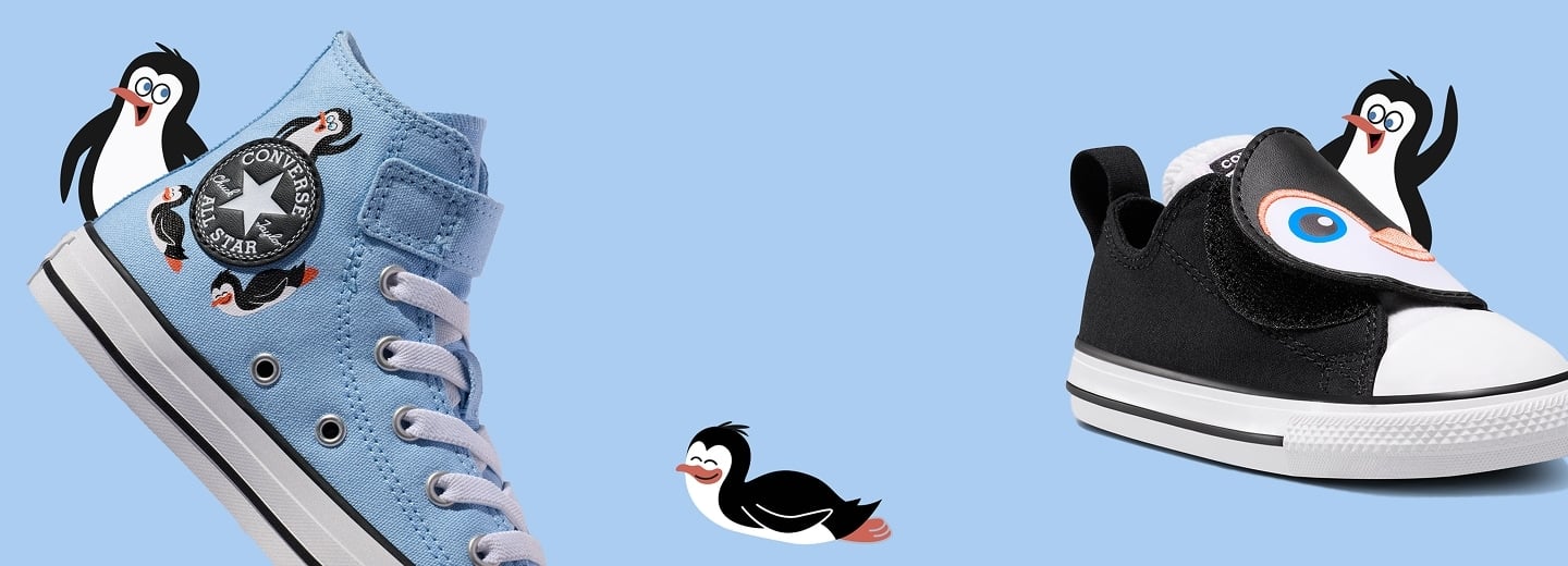 A light blue background shows two children&rsquo;s Converse-style shoes: a sky-blue high-top on the left decorated with small penguin patches and a black low-top on the right with a penguin-face flap. Several small cartoon penguins appear around and between the shoes, including one floating in the center.