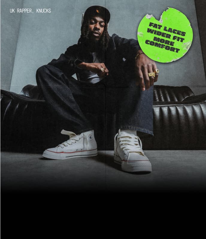 Photo of UK Rapper, Knucks, sitting on a leather couch wearing Chuck Taylor Throwback shoes