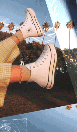 The person is wearing white high-top Converse sneakers with black detailing, paired with light-colored ruffled socks and yellow plaid pants. 