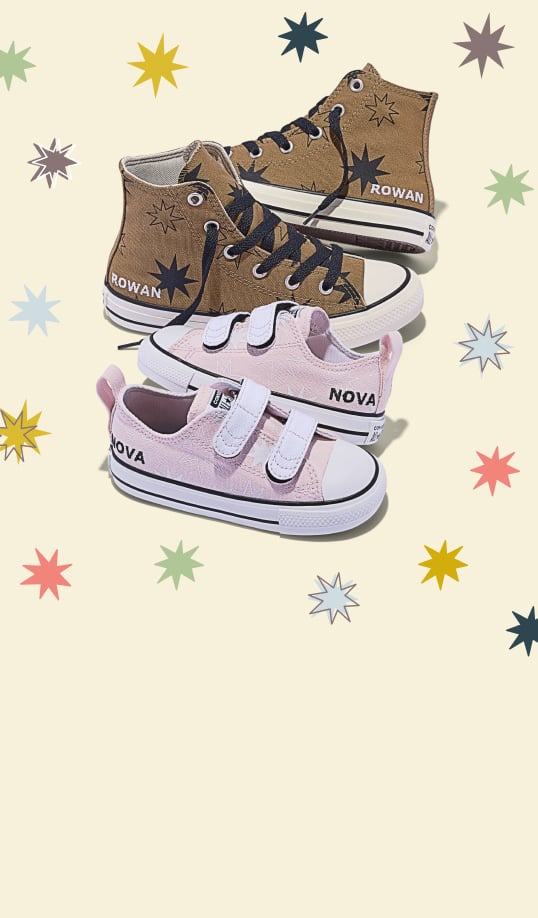 A pair of brown high-top sneakers labeled &ldquo;ROWAN&rdquo; and a pair of pink low-top velcro shoes labeled &ldquo;NOVA&rdquo; are arranged against a pale background. Colorful starburst motifs decorate both the shoes and the surrounding background.