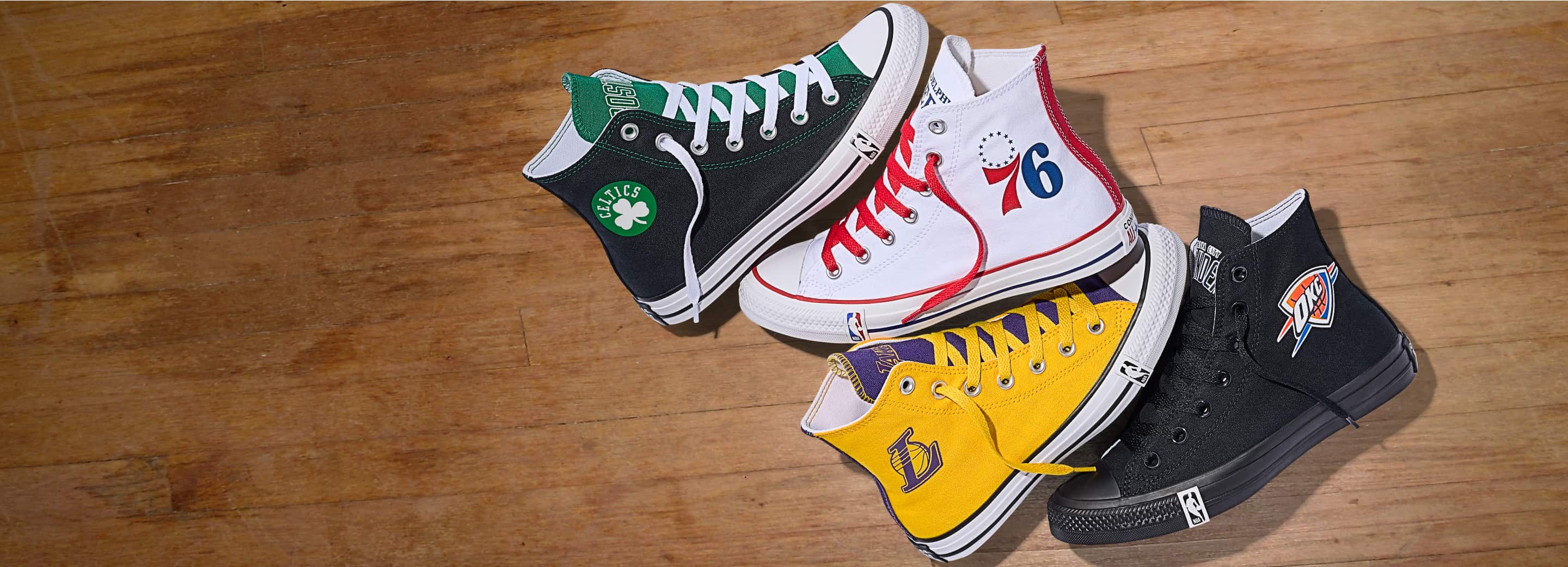 These are Converse Custom NBA shoes featuring designs for the Boston Celtics, Philadelphia 76ers, Los Angeles Lakers, and Oklahoma City Thunder. Each high-top sneaker showcases team colors and logos on classic Converse silhouettes with NBA branding on the soles.