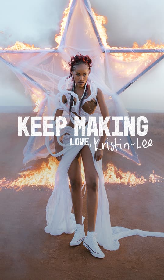 The image shows a person standing in front of a large star-shaped frame that is on fire, with white fabric draped around them. Overlaid text reads &ldquo;KEEP MAKING LOVE, Kristin-Lee.&rdquo;