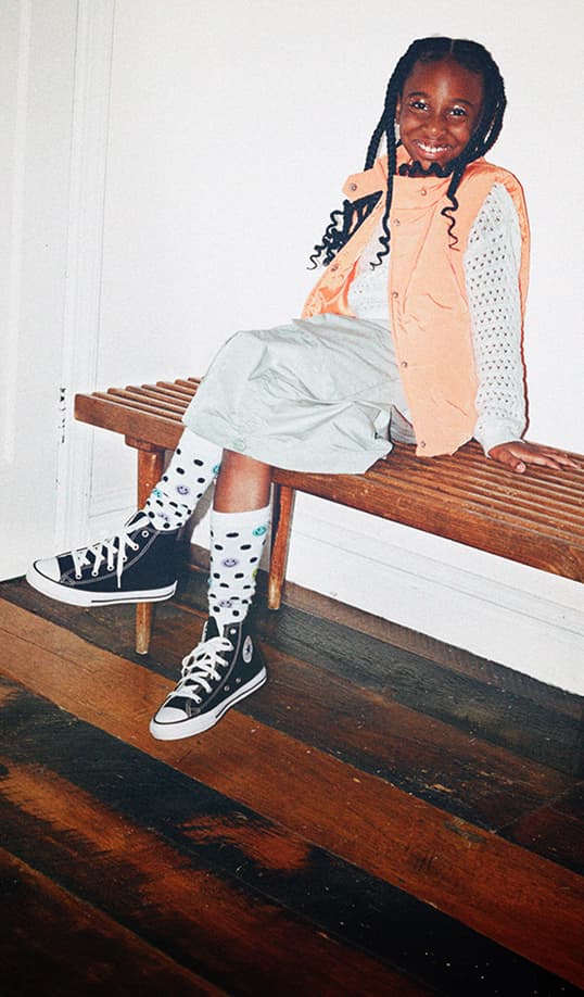 Child wearing black high-top sneakers.